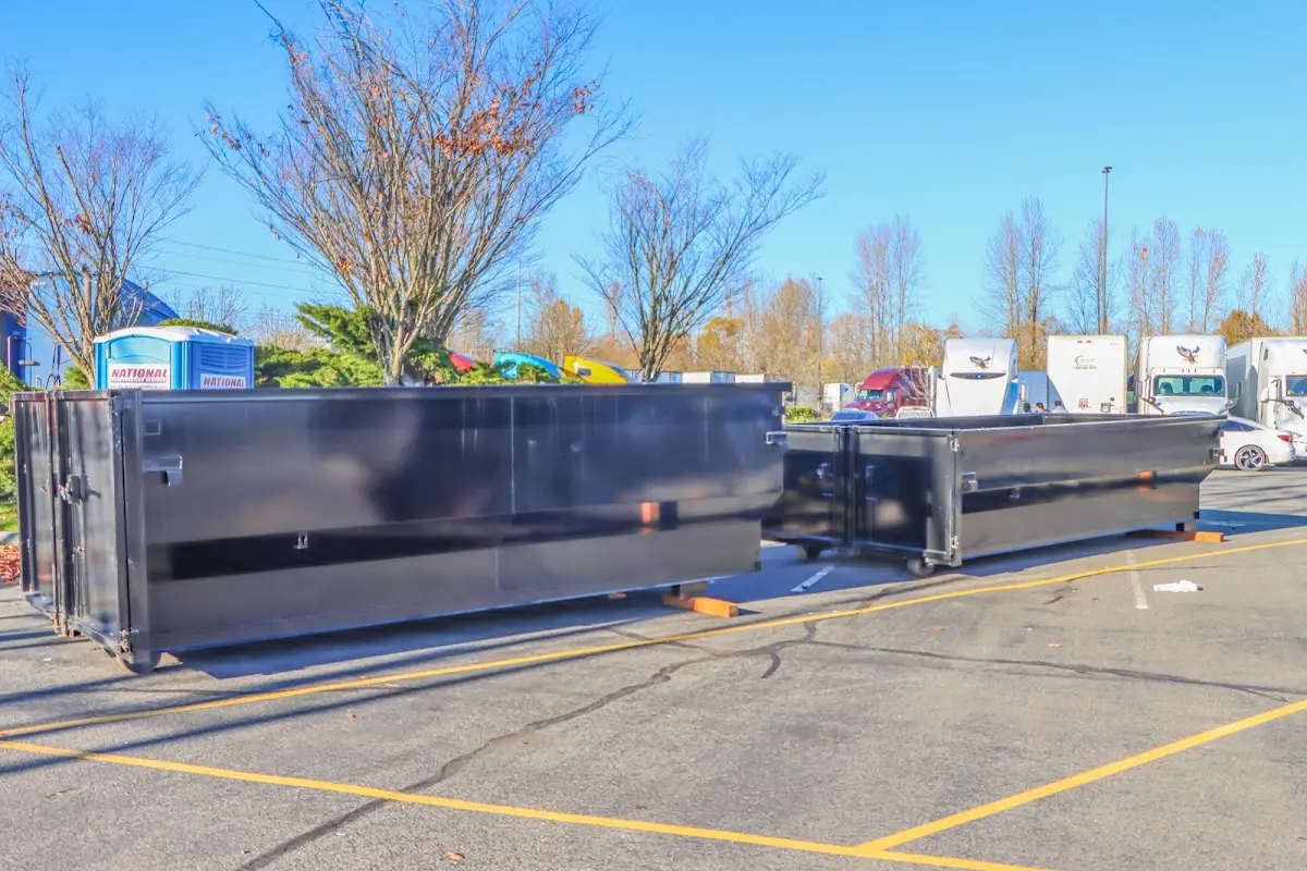 Professional dumpster rental service with roll-off container on residential driveway in Morehead